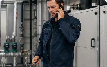 Gebäudetechniker wird während seiner Arbeit durch einen Anruf unterbrochen